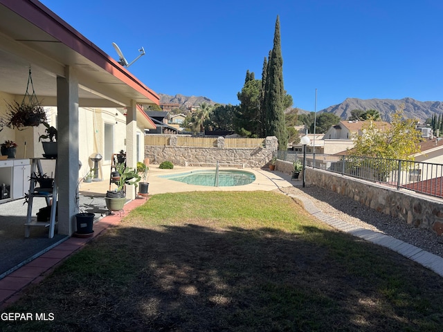 view of yard featuring a fenced in pool, a mountain view, and a patio area