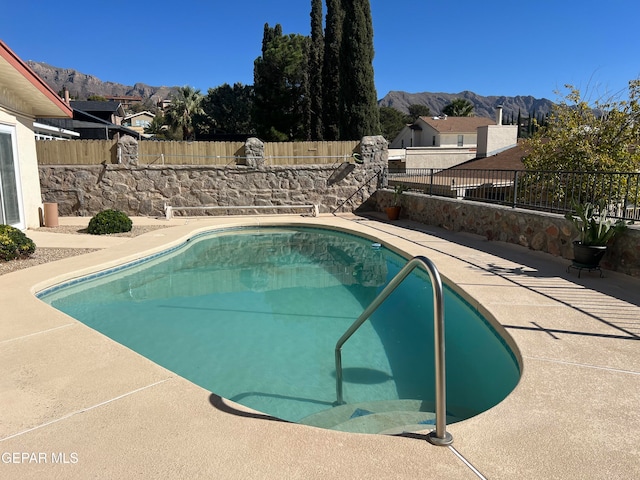 view of swimming pool with a mountain view and a patio