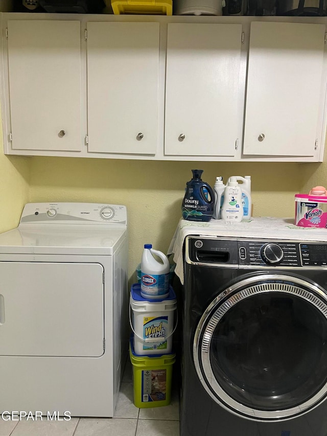 washroom featuring cabinets, washer and dryer, and light tile patterned floors