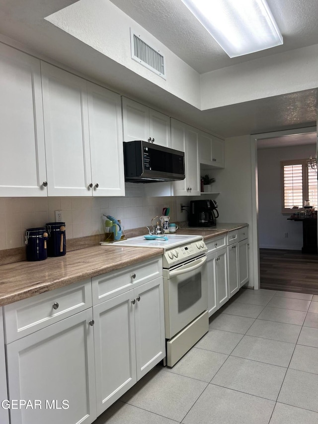 kitchen featuring tasteful backsplash, light tile patterned floors, white electric range, and white cabinets