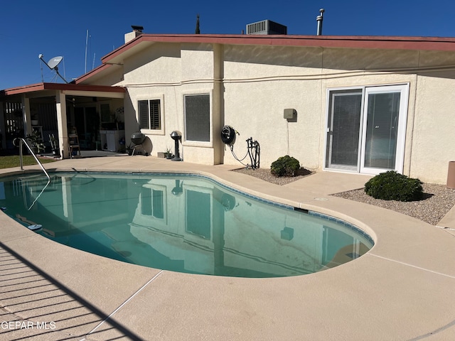 view of swimming pool with central AC unit and a patio