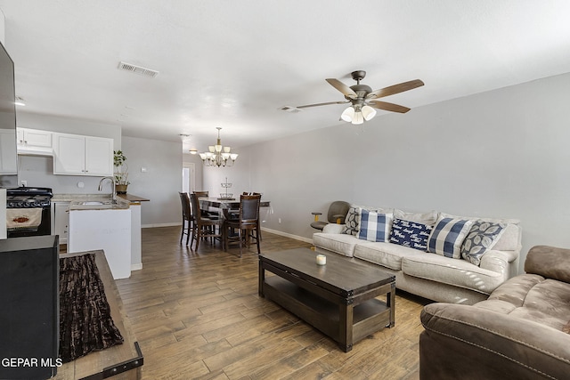 living room with sink, wood-type flooring, and ceiling fan with notable chandelier