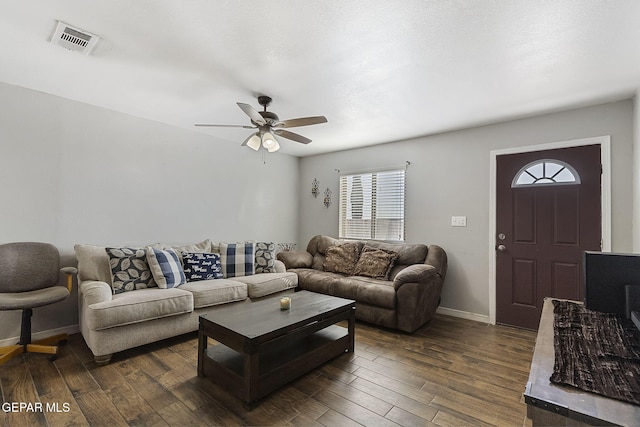 living room with dark hardwood / wood-style flooring, ceiling fan, and a healthy amount of sunlight