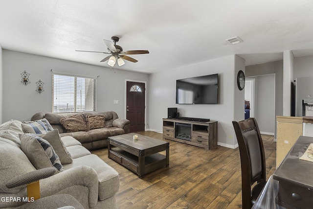 living room with ceiling fan and dark hardwood / wood-style flooring