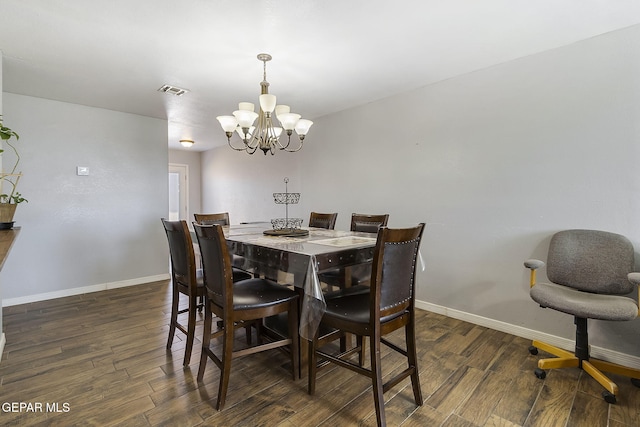 dining room featuring dark wood-type flooring and an inviting chandelier