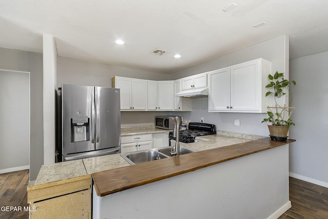 kitchen with dark wood-type flooring, white cabinets, sink, kitchen peninsula, and stainless steel appliances