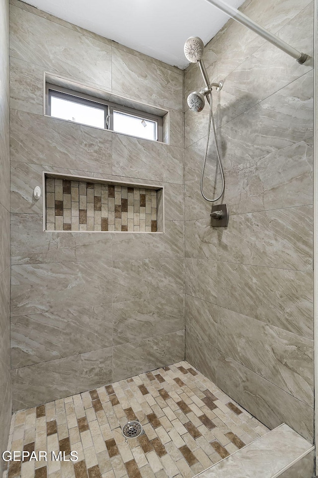 bathroom with a healthy amount of sunlight and a tile shower