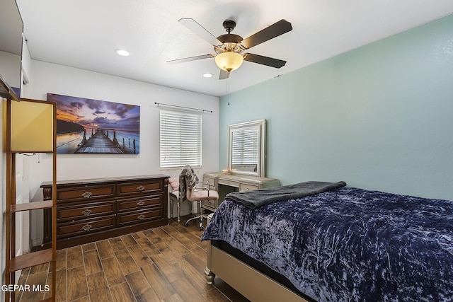 bedroom with ceiling fan, dark hardwood / wood-style flooring, and built in desk