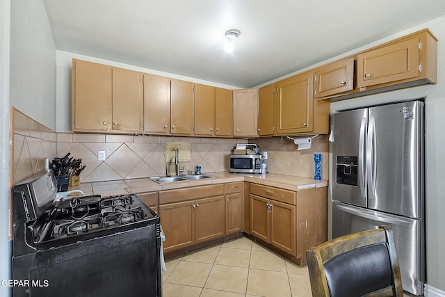 kitchen featuring decorative backsplash, sink, light tile patterned floors, and stainless steel appliances