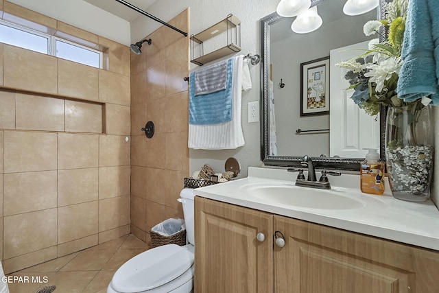 bathroom with vanity, toilet, and a tile shower