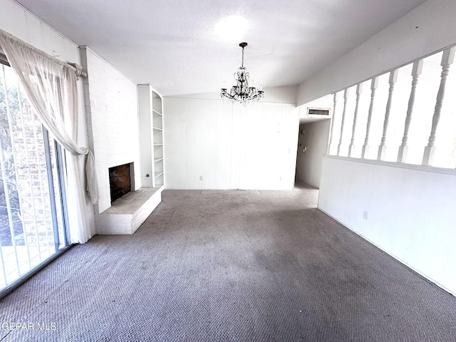 10545 Springwood Dr, El Paso, TX 79925 - unfurnished living room with carpet, a chandelier, a fireplace, built in shelves, and a textured ceiling