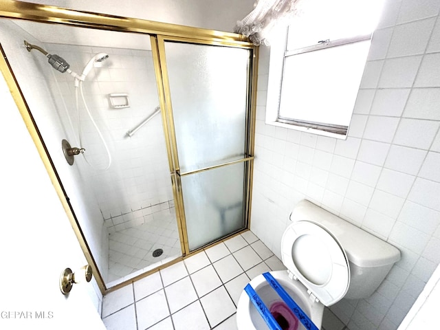 10545 Springwood Dr, El Paso, TX 79925 - bathroom with toilet, a shower stall, tile walls, and tile patterned flooring