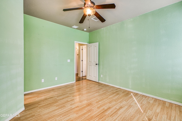 empty room with ceiling fan and light hardwood / wood-style flooring