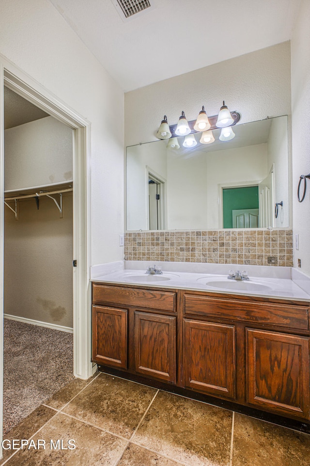 bathroom with tile patterned floors, vanity, and backsplash