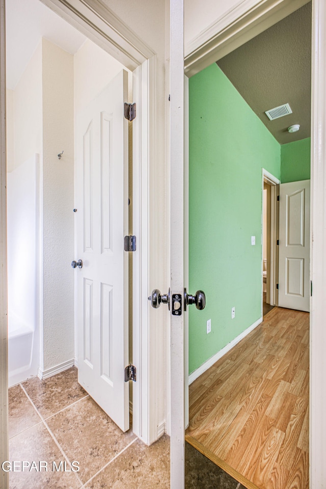 hallway with light hardwood / wood-style floors