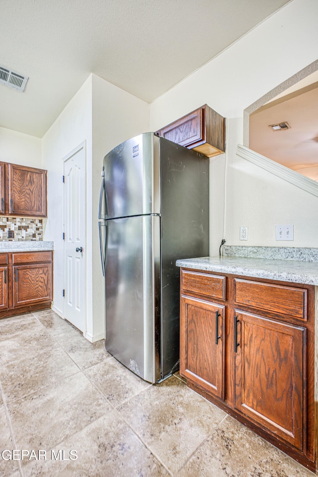 kitchen with stainless steel fridge and light tile patterned floors