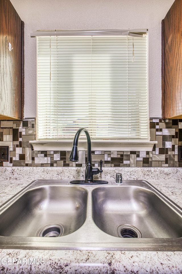 room details featuring tasteful backsplash and sink