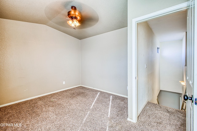 carpeted spare room featuring ceiling fan and lofted ceiling