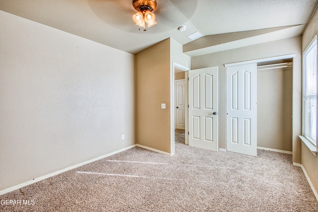 unfurnished bedroom featuring carpet, ceiling fan, lofted ceiling, and a closet