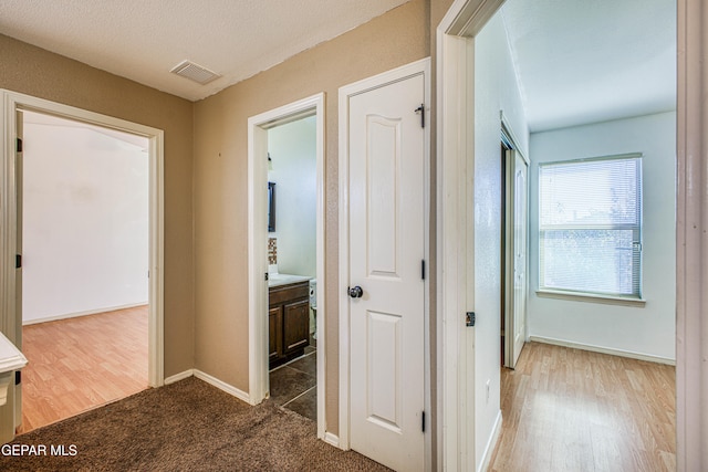 hall featuring hardwood / wood-style floors and a textured ceiling