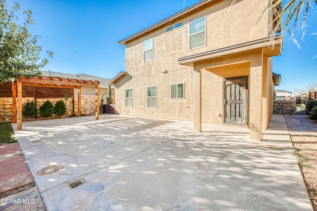 rear view of house featuring a patio and a pergola