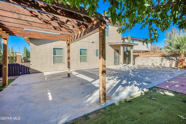 rear view of property featuring a pergola and a patio