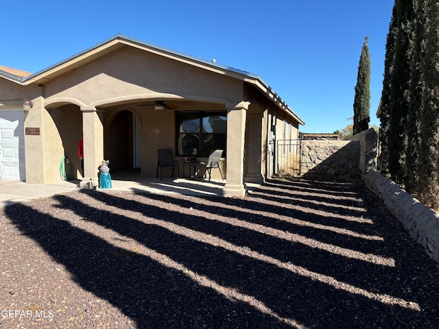 back of house featuring ceiling fan and a garage