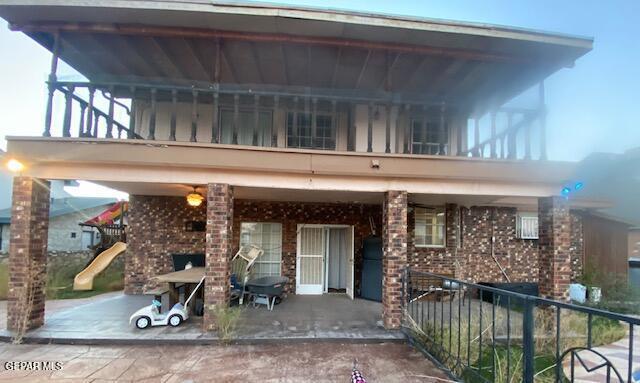 2078 Gus Moran St, El Paso, TX 79936 - view of front of home with brick siding, a balcony, and a playground