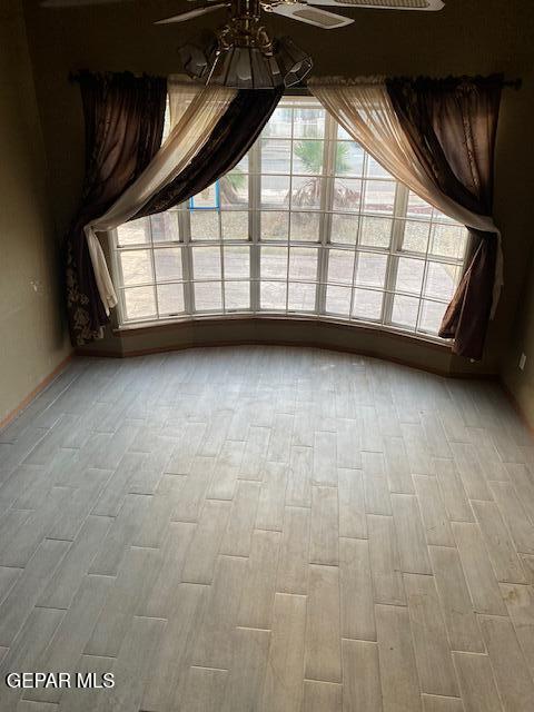 empty room featuring ceiling fan and light hardwood / wood-style flooring