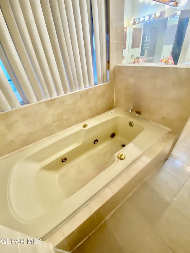 bathroom with a relaxing tiled tub and tile patterned floors