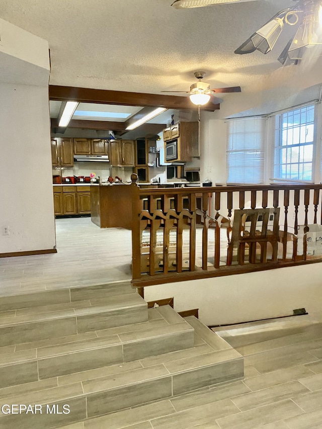 stairway featuring ceiling fan and a textured ceiling