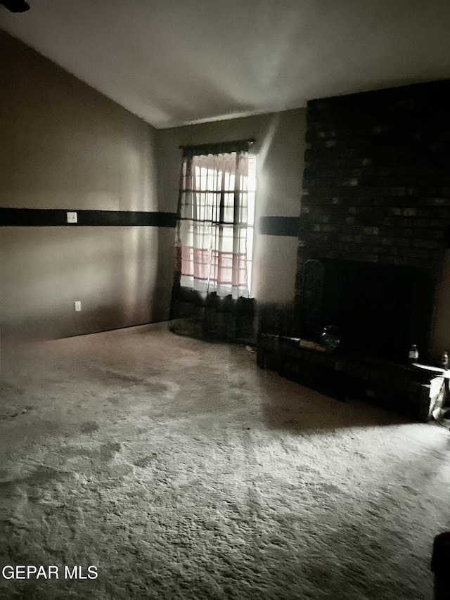 unfurnished living room with lofted ceiling and carpet