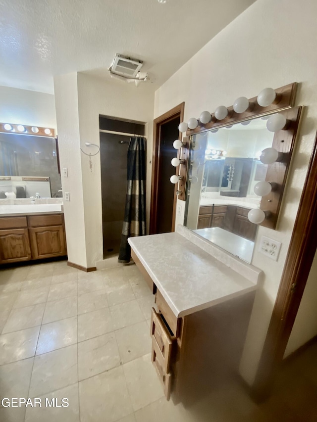 bathroom with light tile patterned floors and a textured ceiling