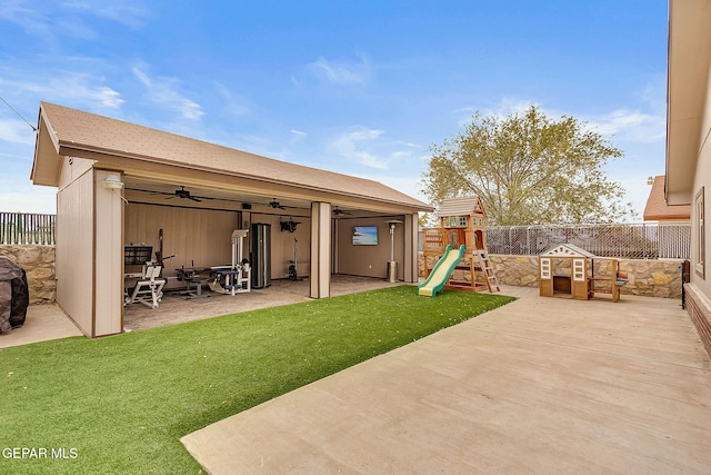 view of patio / terrace featuring ceiling fan, a playground, and water heater