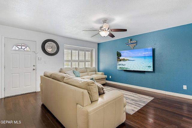 living room with a textured ceiling, ceiling fan, and dark hardwood / wood-style floors