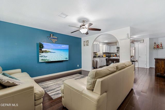 living room with dark hardwood / wood-style floors and ceiling fan