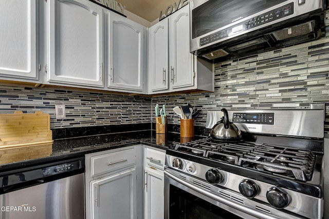 kitchen featuring appliances with stainless steel finishes, tasteful backsplash, dark stone counters, extractor fan, and white cabinets