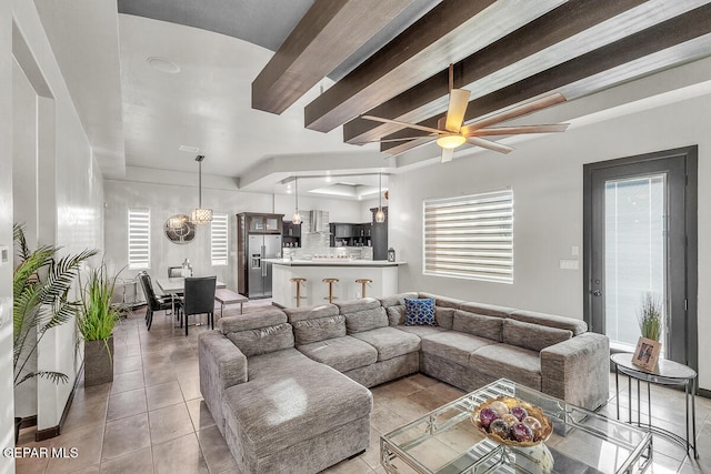 living room with beamed ceiling, plenty of natural light, light tile patterned flooring, and ceiling fan