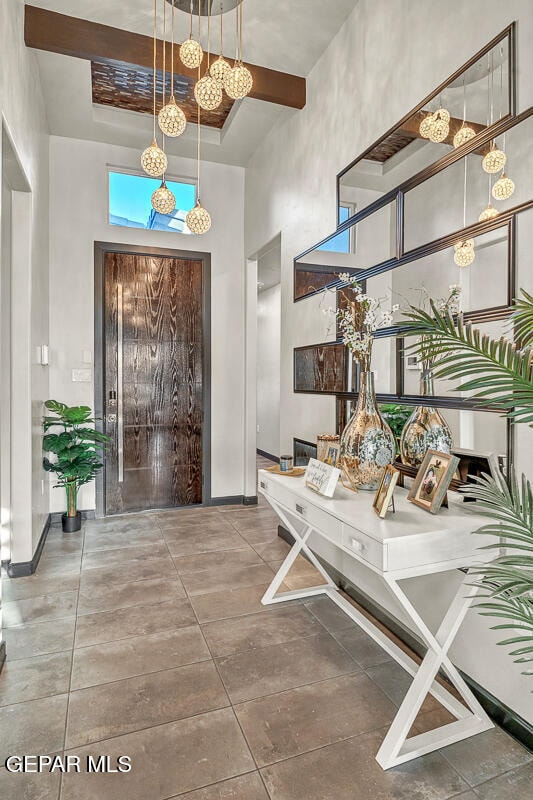 entryway featuring a high ceiling and tile patterned floors