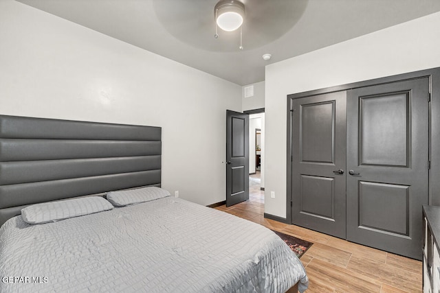 bedroom featuring ceiling fan, a closet, and light hardwood / wood-style flooring