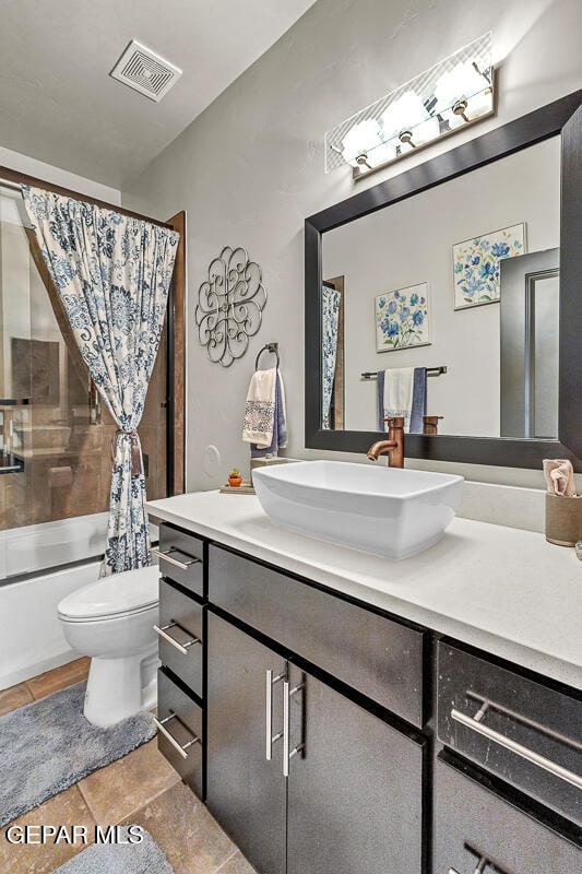 full bathroom featuring tile patterned flooring, vanity, toilet, and shower / tub combo with curtain