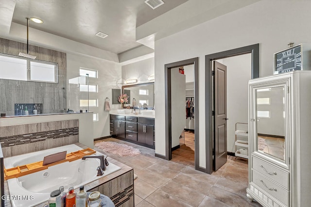 bathroom featuring shower with separate bathtub, vanity, and tile patterned floors