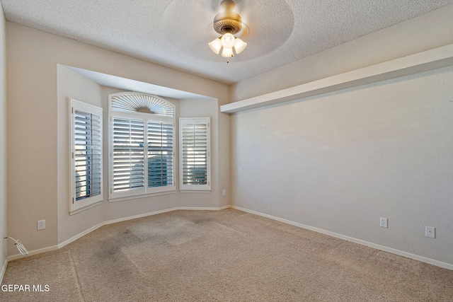 carpeted empty room featuring ceiling fan and a textured ceiling