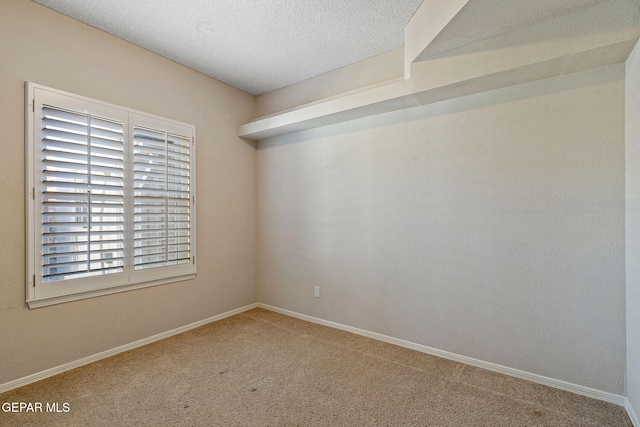 spare room featuring a textured ceiling and carpet floors