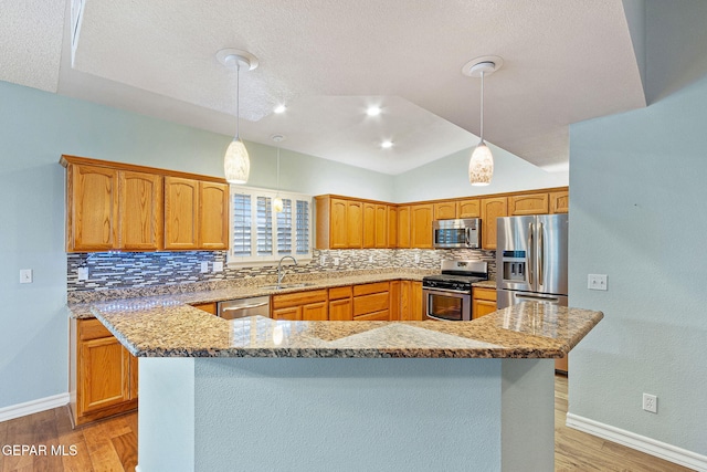 kitchen featuring tasteful backsplash, stainless steel appliances, pendant lighting, light hardwood / wood-style floors, and lofted ceiling