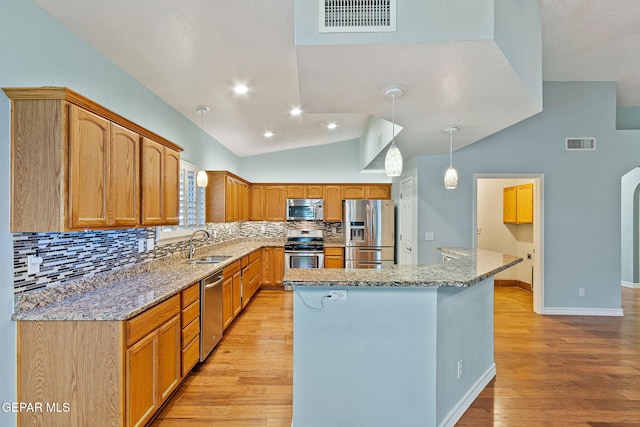 kitchen featuring stainless steel appliances, vaulted ceiling, light hardwood / wood-style floors, and sink