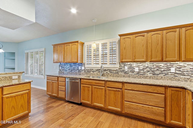 kitchen featuring sink, stainless steel dishwasher, decorative backsplash, light hardwood / wood-style floors, and light stone counters