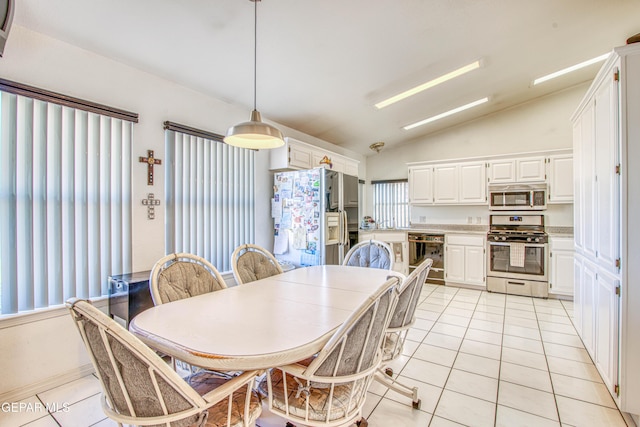 dining space featuring lofted ceiling and light tile patterned floors