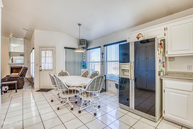 dining room featuring vaulted ceiling and light tile patterned floors