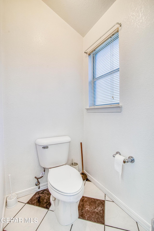 bathroom with toilet and tile patterned flooring